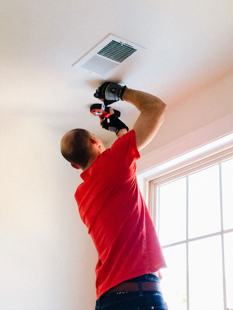 Using a stud finder to mark each ceiling joist