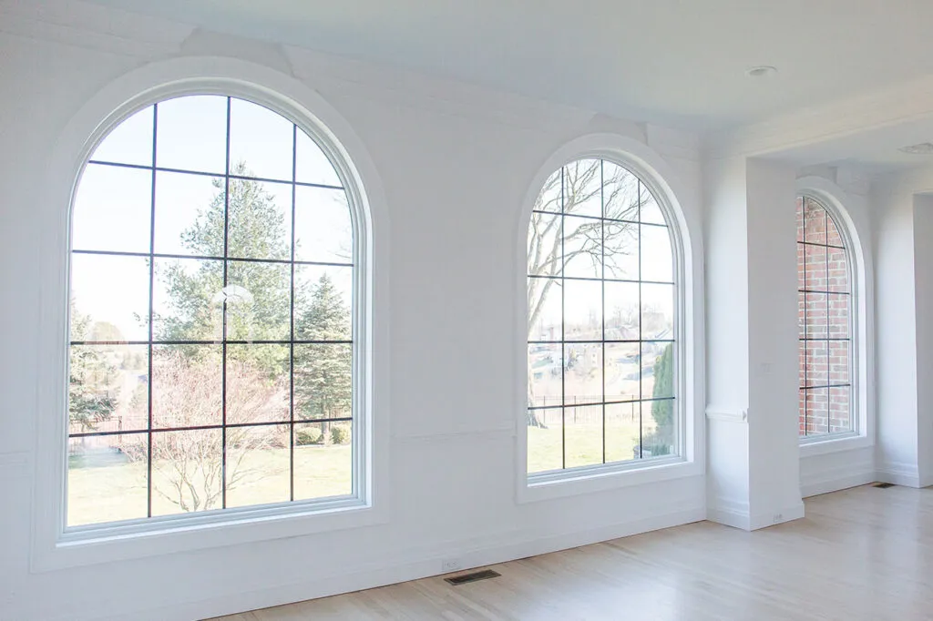 The finished living room windows look great with white trim and black grilles. 