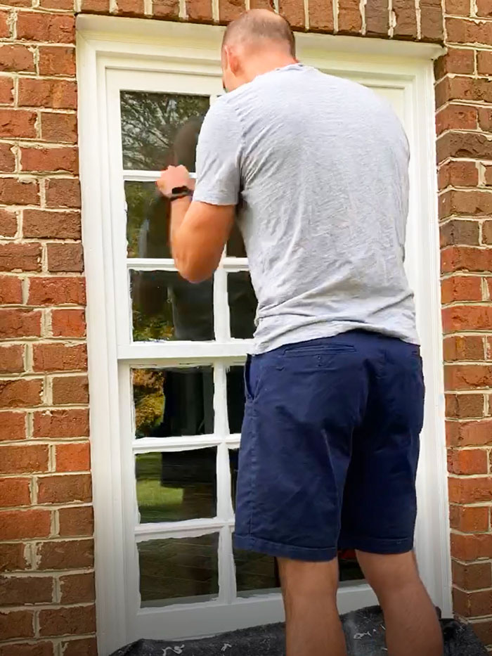 Use a window scraper to remove the excess paint on the glass. 