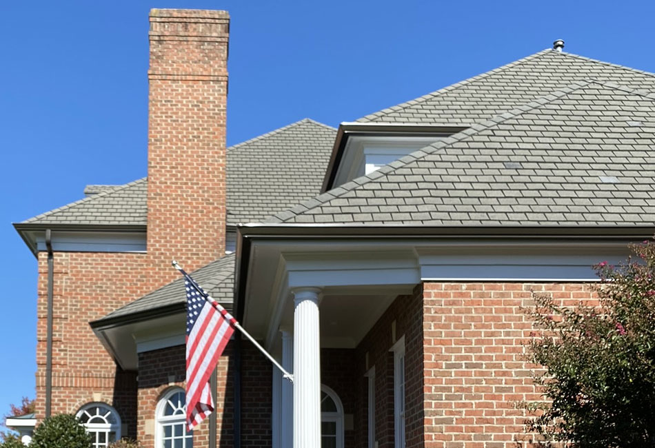 Dark bronze gutters look classic on a red-brick colonial home. 