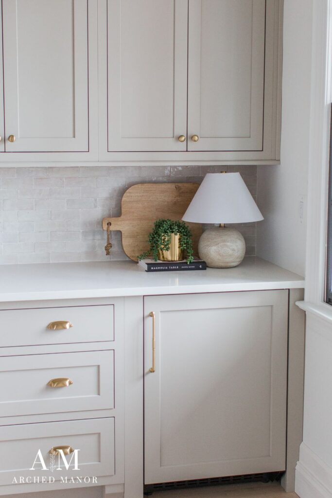 Mushroom Colored inset cabinets with brass hardware