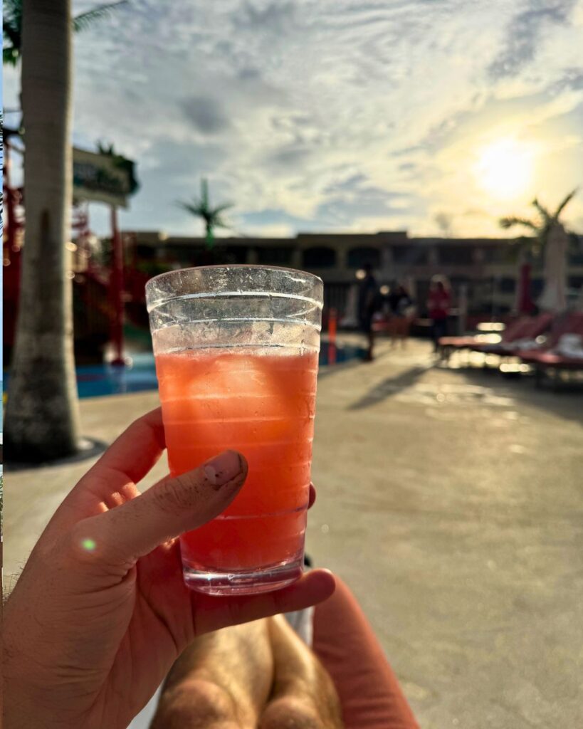 Consuming a nice drink by the pool at sunset.